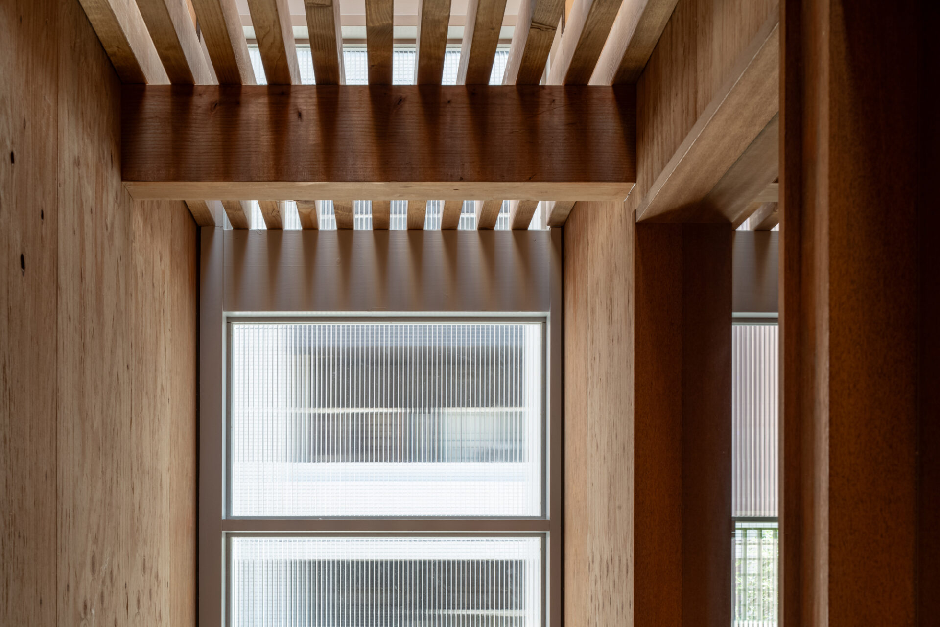 建築写真、内観、2階まで伸びたエントランスの窓から差し込む柔らかい光