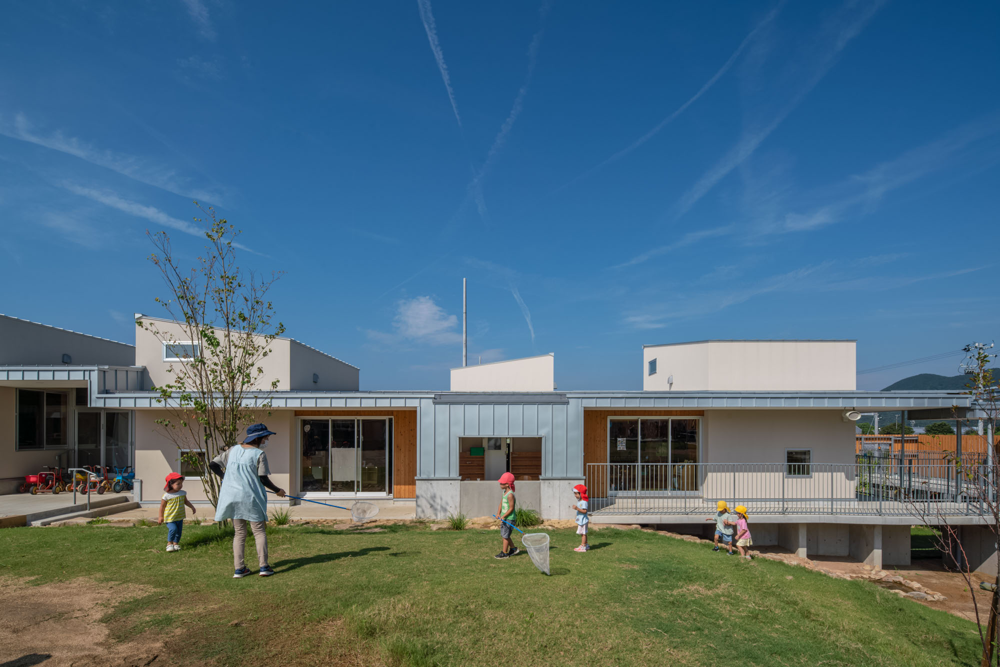 建築写真撮影 こども園の外観
虫取りをする先生と園児たち