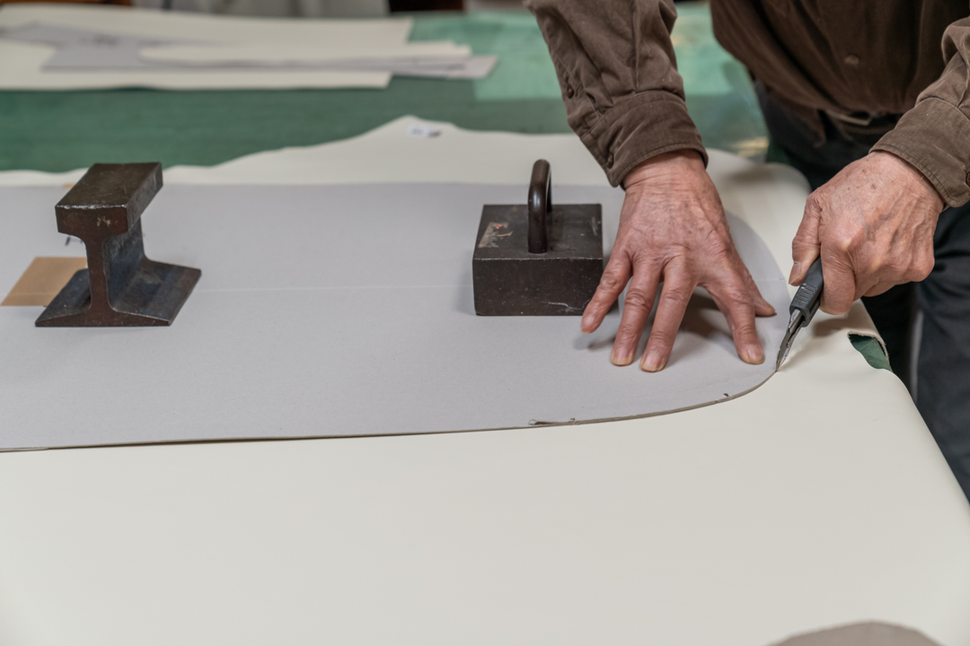 皮革をカッターで切る人